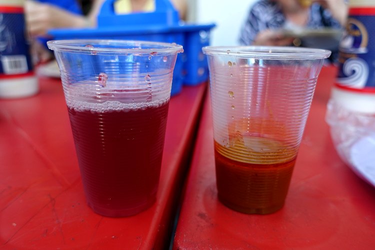 On the left, some fruit juice to wash down the taco. On the right, a sample of the broth in which the stew filling was cooked.