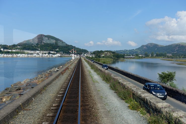 FFESTINIOG RAILWAY: Leaving Porthmadog and running along the embankment known as 'The Cob'